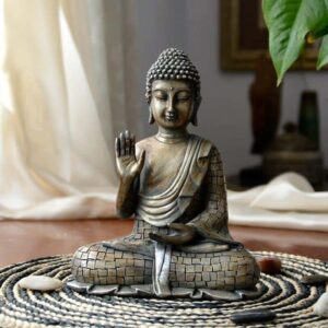 Symbole spirituels au yoga : statuette de Bouddha avec la main droite en abhaya mudra, paume ouverte, doigts  joints.